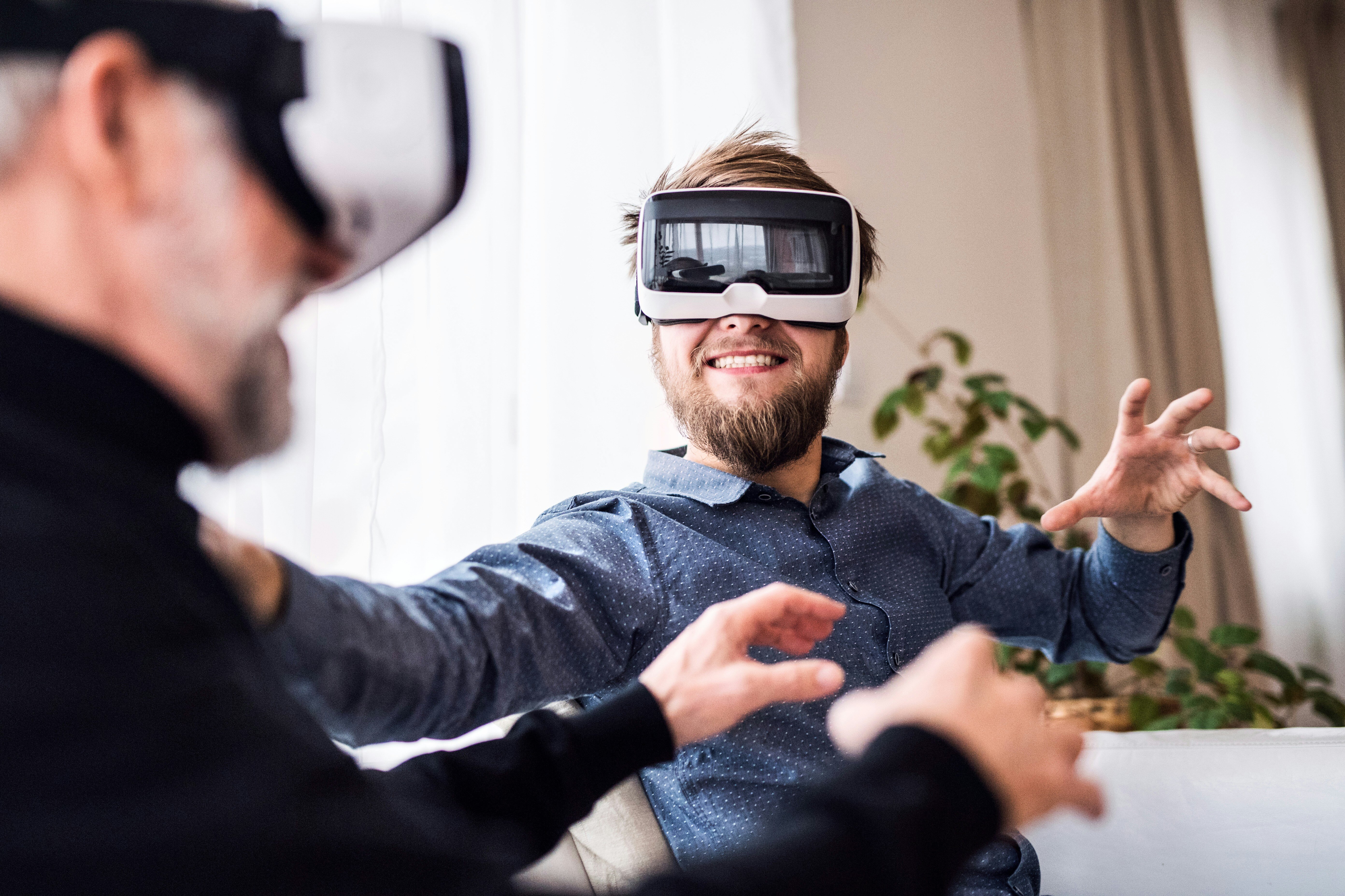 Two people enthusiastically using virtual reality headsets, interacting and experiencing immersive digital environments together